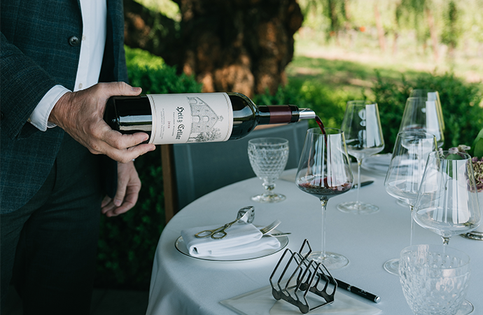 A waiter pouring a glass of Heitz Cellar wine 