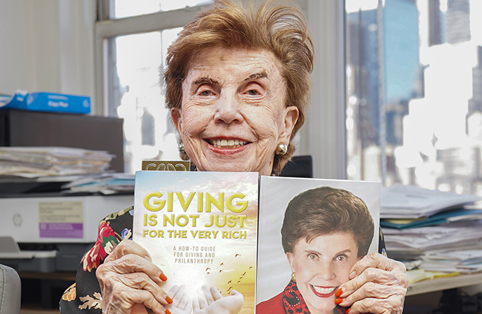 Author Dr. Susan Aurelia Gitelson holding her books, Giving is Not Just for the Very Rich and A Zest for Life